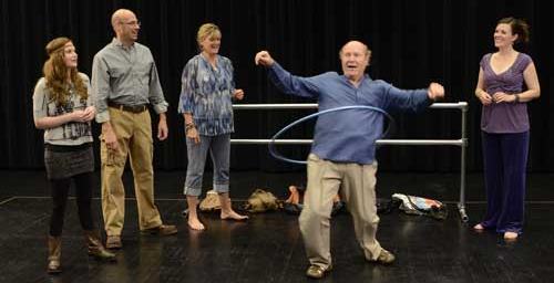 David demonstrates his skill with the hula hoop while his castmates watch. (Photo by John Groseclose.)